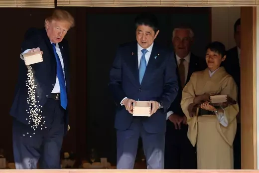 U.S. President Donald Trump and Japan's Prime Minister Shinzo Abe feed koi fish at Akasaka Palace in Tokyo, Japan, on November 6, 2017. 