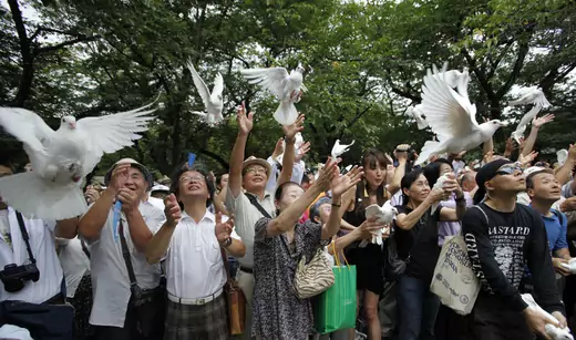 People release doves as a symbol of peace at the Yasukuni Shrine for the war dead in Tokyo August 15, 2012, on the anniversary of Japan's surrender in World War II.