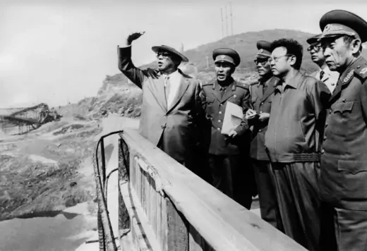 Kim Il-sung and Kim Jong-il oversee the construction of a dam.