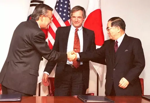 Representatives of Japan, South Korea, and the United States sign the KEDO treaty.