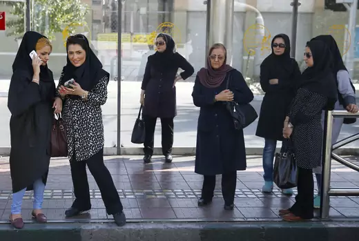 Women wait for a bus in central Tehran, Iran 