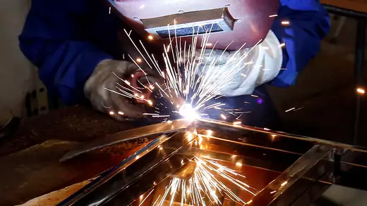 A woman welds a table at Xuan Hoa furniture factory in Xuan Hoa town