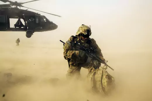 A U.S. soldier from the 3rd Cavalry Regiment shields himself from the rotor wash of a UH-60 Blackhawk helicopter after being dropped off for a mission with the Afghan police near Jalalabad in the Nangarhar province of Afghanistan.