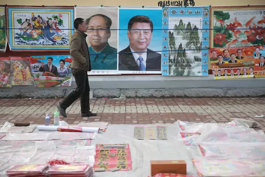 A man walks past New Year decoration pictures featuring China's President Xi Jinping, China's late Chairman Mao Zedong and some other current senior officials, at a market in Juancheng, Shandong province, February 17, 2015. The Chinese Lunar New Year on Feb. 19 will welcome the Year of the Sheep (also known as the Year of the Goat or Ram).