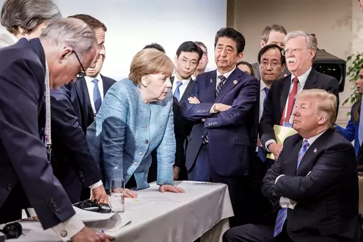 Angela Merkel speaks to Donald Trump during the second day of the G7 meeting, 2018