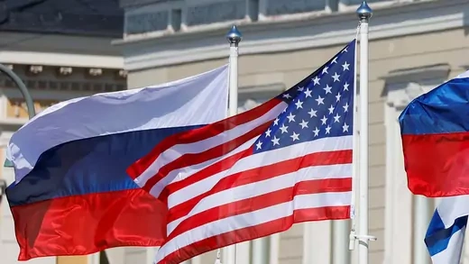 U.S. and Russian flags are seen flying outside the Russian Presidential Palace