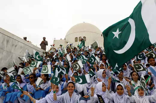 Attendees wave Pakistan's national flag while singing national songs at a ceremony to celebrate the country's 71st Independence Day at the mausoleum of Muhammad Ali Jinnah in Karachi, Pakistan August 14, 2018. REUTERS/Akhtar Soomro