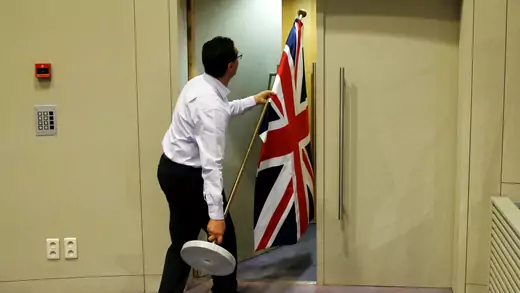 An official carries a Union Jack flag ahead of a news conference by Britain's Secretary of State for Exiting the European Union David Davis and European Union's chief Brexit negotiator Michel Barnier in Brussels, Belgium on July 20, 2017.