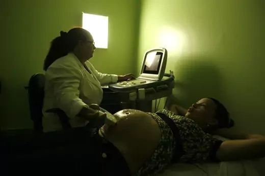Pregnant patient Angelica Martinez is checked by a doctor at a health program in Caracas.