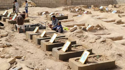 Abdullah al-Khawlani sits by his son Waleed's grave, who was killed by last month's Saudi-led air strike that killed dozens, including children in Saada, Yemen September 4, 2018. His other son, Hafidh, who survived the strike, sits next to him.