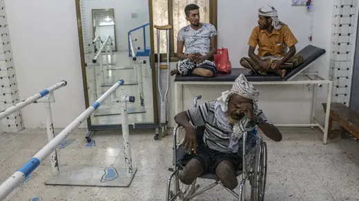 A man waits to be fitted for a set of prosthetic limbs at a government health clinic in Aden.