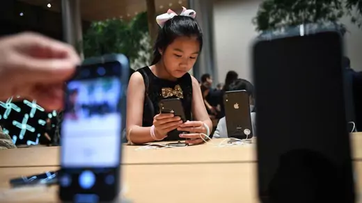 Young girl checks out an iPhone in November 2018.