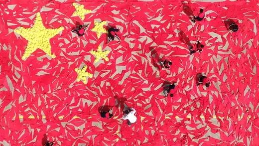 Students use red scarves and yellow hats to make the pattern of the Chinese national flag at a primary school in Linyi, Shandong Province. 