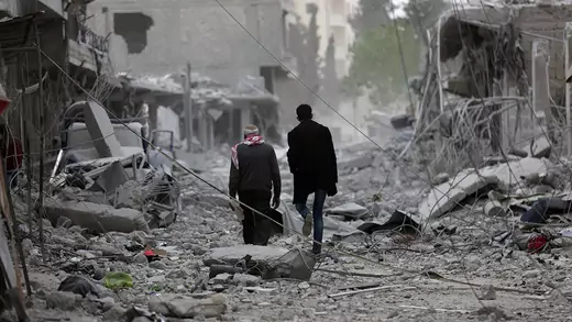 Men walk through debris in the center of Afrin, Syria.