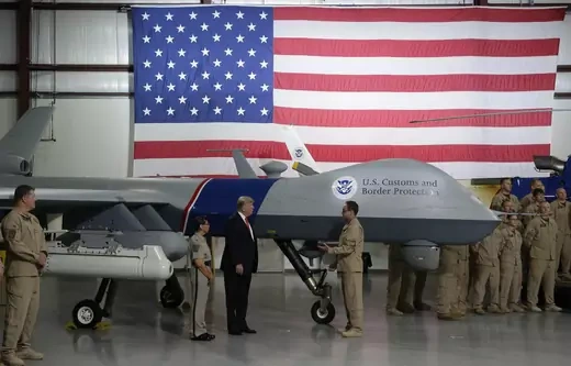 U.S. President Donald Trump puts his hand on a drone aircraft used to patrol the border at U.S. Customs and Border Patrol facility in Yuma, Arizona, U.S., August 22, 2017.