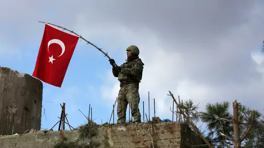 A Turkish soldier waves a flag on Mount Barsaya, northeast of Afrin, Syria January 28 ,2018. 