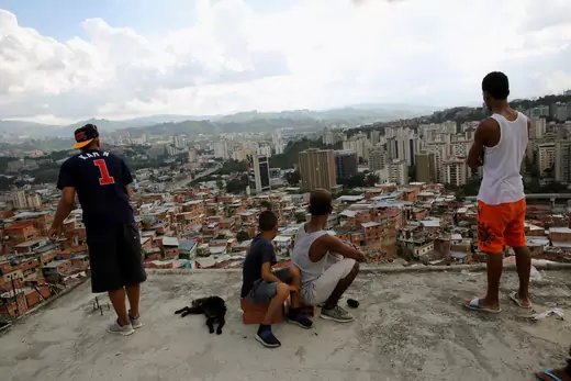 Four boys look ahead as one flies a kite over houses in the Petare slum in Caracas, Venezuela. 