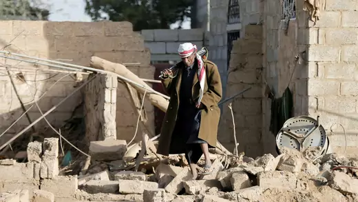 A man walks at the site of a Saudi-led air strike in Sana'a
