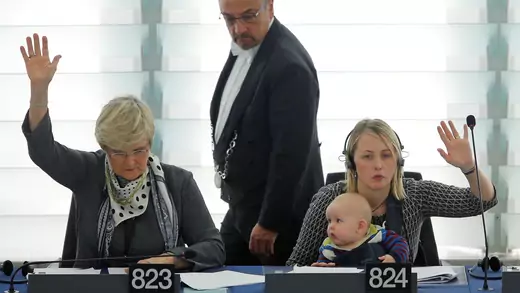 Swedish Member European Parliament Jytte Guteland (R) holds her baby as she takes part in a voting session at the European Parliament.