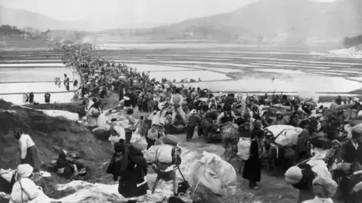 South Korean refugees block the road bridge across rice paddies as they flee advancing Communists South of Seoul