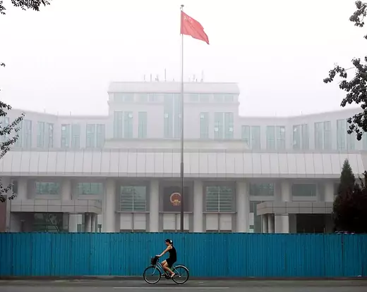 A Chinese woman rides past Beijing Intermediate People's Court in Beijing July 24, 2001.