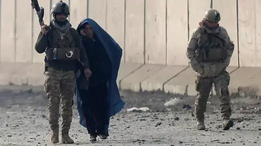 Afghan security forces escort a woman at the site of a car bomb blast in Kabul, Afghanistan January 15, 2019.