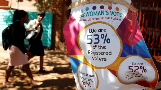 Women walk past Zimbabwe Electoral Commission (ZEC) posters in Harare, Zimbabwe, July 26, 2018.