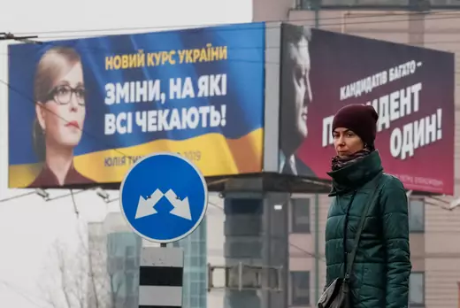 A man stands in front of pre-election posters of opposition politician Yulia Tymoshenko and Ukrainian President Petro Poroshenko in Kiev, Ukraine February 20, 2019. Posters read: "New course of Ukraine. The changes that we are waiting for." and "There are a lot of candidates - there is only one President." 