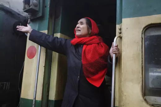 An Indian woman gestures to her relatives as she leaves a railway station in Lahore, Pakistan.