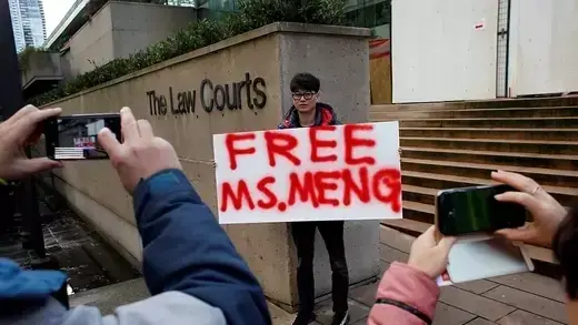 A man holds a sign outside of the B.C. Supreme Court bail hearing of Meng Wanzhou.