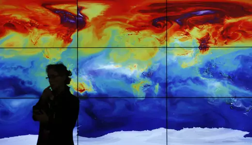 A participant in front of a screen showing a world map during the World Climate Change Conference 2015 (COP21) at Le Bourget, near Paris, France, December 8, 2015. 