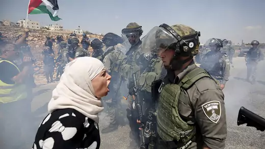 A Palestinian woman argues with an Israeli border policeman in the West Bank.