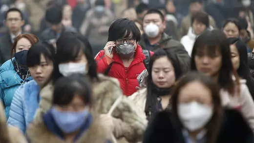 Commuters wearing masks make their way amid thick haze in the morning in Beijing, China.