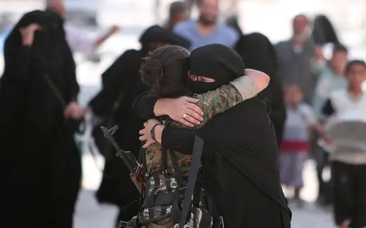 A woman embraces a Syria Democratic Forces (SDF) fighter after she was evacuated with others by the SDF from an Islamic State-controlled neighbourhood of Manbij, in Aleppo Governorate, Syria, August 12, 2016.