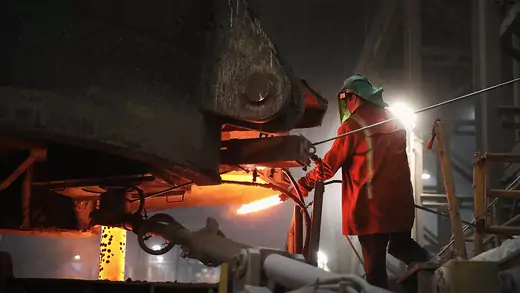 A steelworker tests a sample of steel at an Indiana mill in March 2018.
