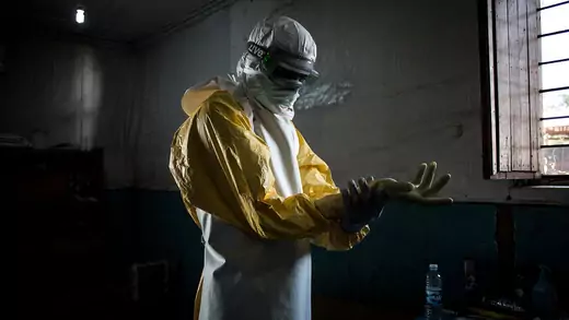 A health worker puts on personal protective equipment before entering the red zone of an Ebola treatment center, where he will check up on patients in Bunia, Democratic Republic of Congo.
