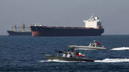 Iranian sailors pass oil tanker in the Strait of Hormuz