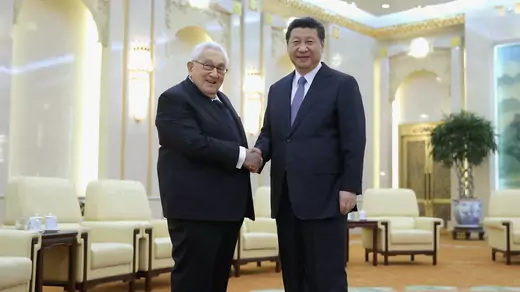 Xi Jinping and Henry Kissinger shaking hands