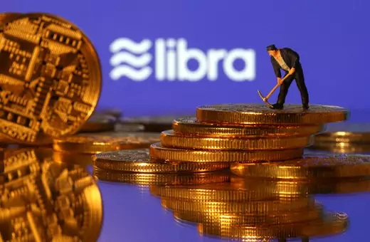 A small toy figure stands on representations of virtual currency in front of the Libra logo in this illustration picture, June 21, 2019.