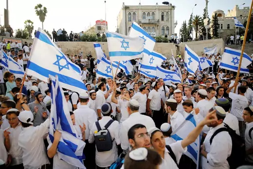 Jewish youth wave Israeli flags as they participate in a march marking "Jerusalem Day", near Damascus Gate in Jerusalem's Old City June 2, 2019.