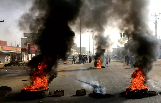 Sudanese protesters use burning tires as a barricade in Khartoum.