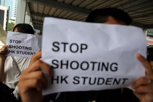 Protesters hold signs following a day of violence in Hong Kong.