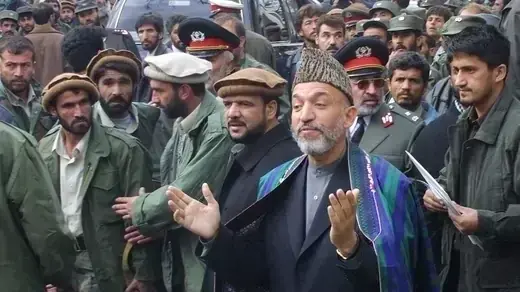 Hamid Karzai surrounded by crowd in Kabul.
