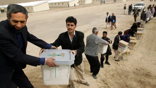 Afghan election officials pass presidential election ballots.