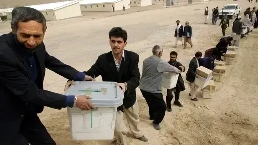 Afghan election officials pass presidential election ballots.