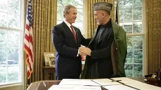 President Bush and President Karzai shaking hands in the Oval Office.