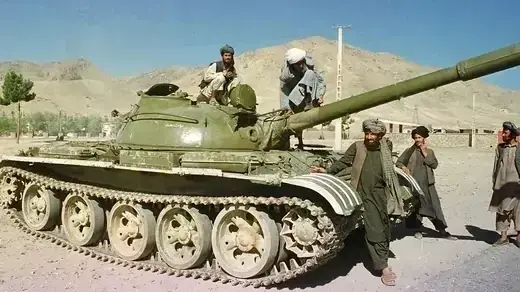 Taliban soldiers sit on tank on the outskirts of Kabul.