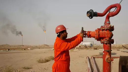 A worker adjusts the valve of an oil pipe at a refinery in Najaf, Iraq.