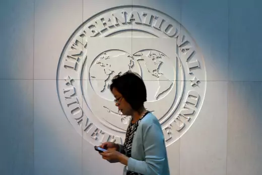 A woman walks past the International Monetary Fund (IMF) logo at its headquarters in Washington, U.S., May 10, 2018. REUTERS/Yuri Gripas
