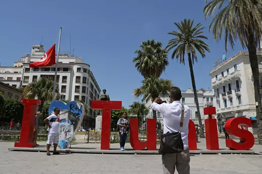 People pose for a photo with "I love Tunis" sign as a Tunisian flag flies at half-mast in honor of late Tunisian President Beji Caid Essebsi, in Tunis, Tunisia July 28, 2019.